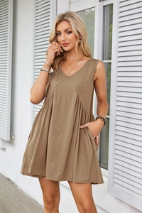 Detail view of V-neck sleeveless dress with side pockets and elegant pleated waist design