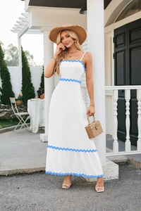 Detail of scalloped blue trim and ruffled hem on white sleeveless summer dress