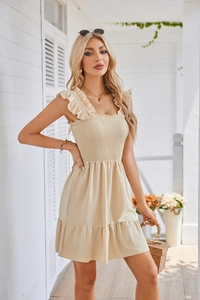 Detail of smocked bodice and ruffle shoulder straps on a beige summer dress