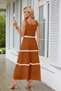 Dettaglio del completo color caramello con finiture in pizzo bianco su top e gonna a balze