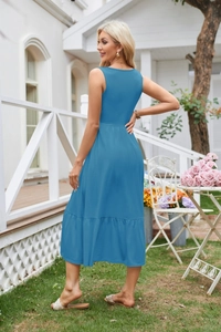 Outdoor back view of blue sleeveless square neck dress with ruffled hem in garden