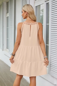 Vista dettagliata del retro dell'abito beige a balze con pizzo e scollatura all'americana