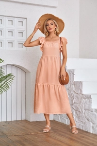 Detail of coral ruffle sleeve dress showing the smocked square neck and tiered skirt texture