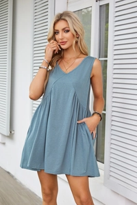 Detail of V-neck sleeveless dress featuring pleated waist and functional side pockets