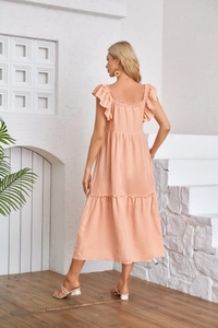 Detail of the layered tiered skirt and ruffled cap sleeves on a peach summer dress