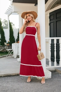 Detailed view of red sundress with white scalloped lace edges and woven texture