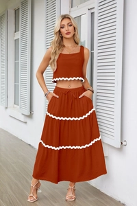 Dettaglio del set due pezzi arancione con bordo smerlato bianco e coulisse in vita elasticizzata