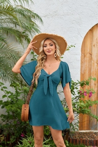 Detail of V-neck teal mini dress featuring decorative bow tie and ruffled short sleeves