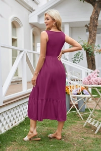 Detail of plum purple sleeveless dress with pleated tiered hem in a garden setting