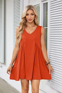 Detail of V-neck orange summer dress with sleeveless pleated waist and functional pockets