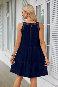 Dettaglio posteriore di un abito blu navy a balze con pizzo e chiusura a goccia sul retro