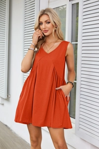 Close-up of sleeveless V-neck dress featuring pleated waist and functional side pockets