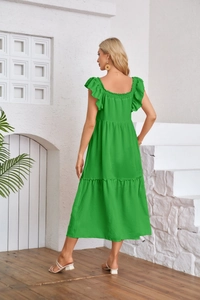 Back view of a tiered ruffle green midi dress with flutter sleeves and elastic smocking