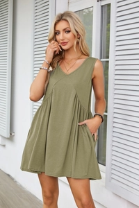 Close-up of olive green sleeveless mini dress showing V-neckline and pleat details
