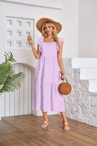 Detail of lavender tiered dress with ruffle sleeves and textured pleats in outdoor setting