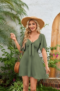 Detail of olive green V-neck mini dress showing textured fabric and bow-tie front