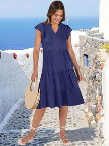 Navy V-neck tiered midi dress with ruffle sleeves in a vacation setting