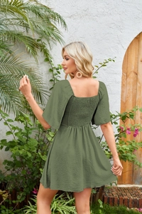 Detail of smocked elastic back panel and puff sleeves on olive green mini dress