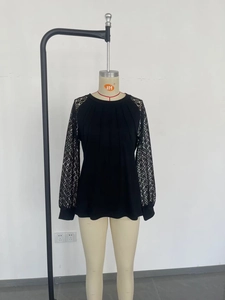 Detail of black long sleeve top showing lace floral sleeves and vertical pleated fabric