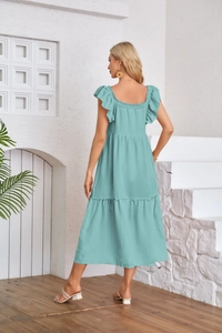 Close-up of mint green square neck dress with ruffled sleeves and tiered pleats