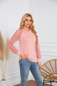 Detail of pink long sleeve knit top with lace patchwork sleeves and pleated neckline
