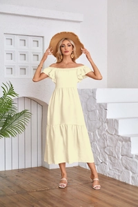 Detail of the light yellow off-the-shoulder dress with smocked square neck and ruffles