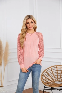 Detail of pink long sleeve top featuring lace patchwork sleeves and pleated neckline