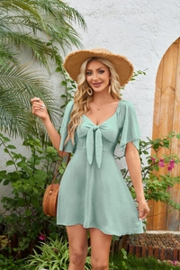 Detail of mint green V-neck mini dress showing bow-tie front and ruffled short sleeves