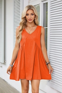 Detail of orange-red V-neck sleeveless dress featuring elegant waist pleats and soft fabric