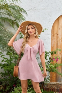 Detail of V-neck tie bow and ruffle short sleeves on a pink mini vacation dress