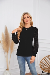 Detail shot of female black long sleeve top featuring intricate floral lace patchwork sleeves