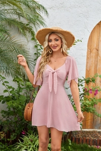 Detail of V-neck tie and textured bubble crepe fabric on a dusty rose mini dress