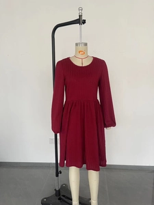 Détail de la texture tricotée rouge vin et des plis de taille sur la robe longue