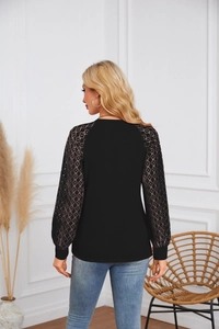 Back view of a long-sleeve black top featuring elegant lace patchwork on the sleeves