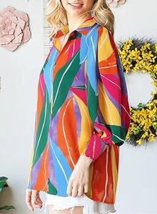 Detail view of colorful tropical leaf print shirt with lapel collar and lantern sleeves