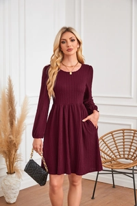 Détail de la robe en maille bordeaux évasée avec texture verticale et poches