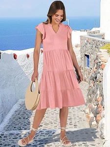 Detail of pink summer V-neck dress featuring tiered cake skirt and ruffle sleeves
