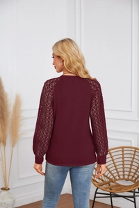 Rear view of wine red long sleeve top featuring intricate lace patchwork sleeves