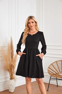 Détail de la texture d'une robe trapèze noire en tricot à manches longues et poches