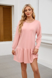 Detail of pink long sleeve dress showing the round neck with crossover stitching and ruffled hem