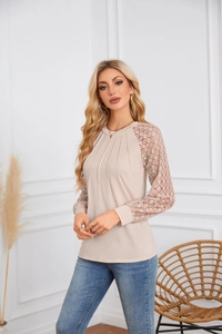 Detail of elegant beige long sleeve top with lace sleeves and pleated neckline texture