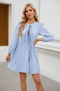 Dettaglio di un abito babydoll azzurro con scollo a lacci e bordo plissettato a balze