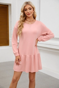 Detail of pink crewneck sweatshirt dress featuring ruffled hem and ribbed sleeve cuffs