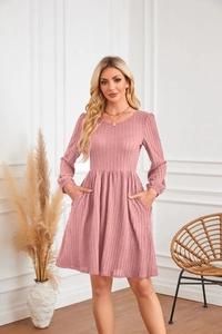 Détail de la robe en maille rose avec texture côtelée, col rond et poches latérales
