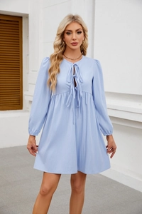 Dettaglio dell'abito babydoll azzurro con tessuto a pieghe e fiocco sullo scollo rotondo