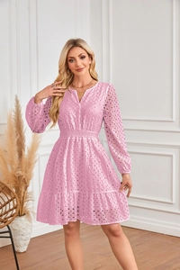 Dettaglio dell'abito rosa con scollo a V, ricamo a occhielli e balze sulla gonna