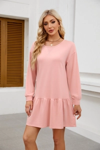 Detail showing the light pink long sleeve dress with a flounce hem and elastic cuffs