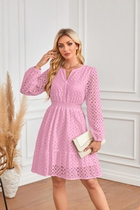 Dettaglio dell'abito rosa con scollo a V, ricamo a occhielli e gonna a balze a strati