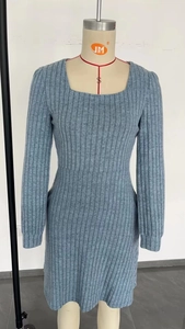 Détail d'une robe en maille bleu-gris avec col carré, texture côtelée et coupe ajustée