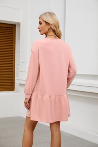 Detail view of pink long sleeve dress with ruffle hem and drop shoulder design